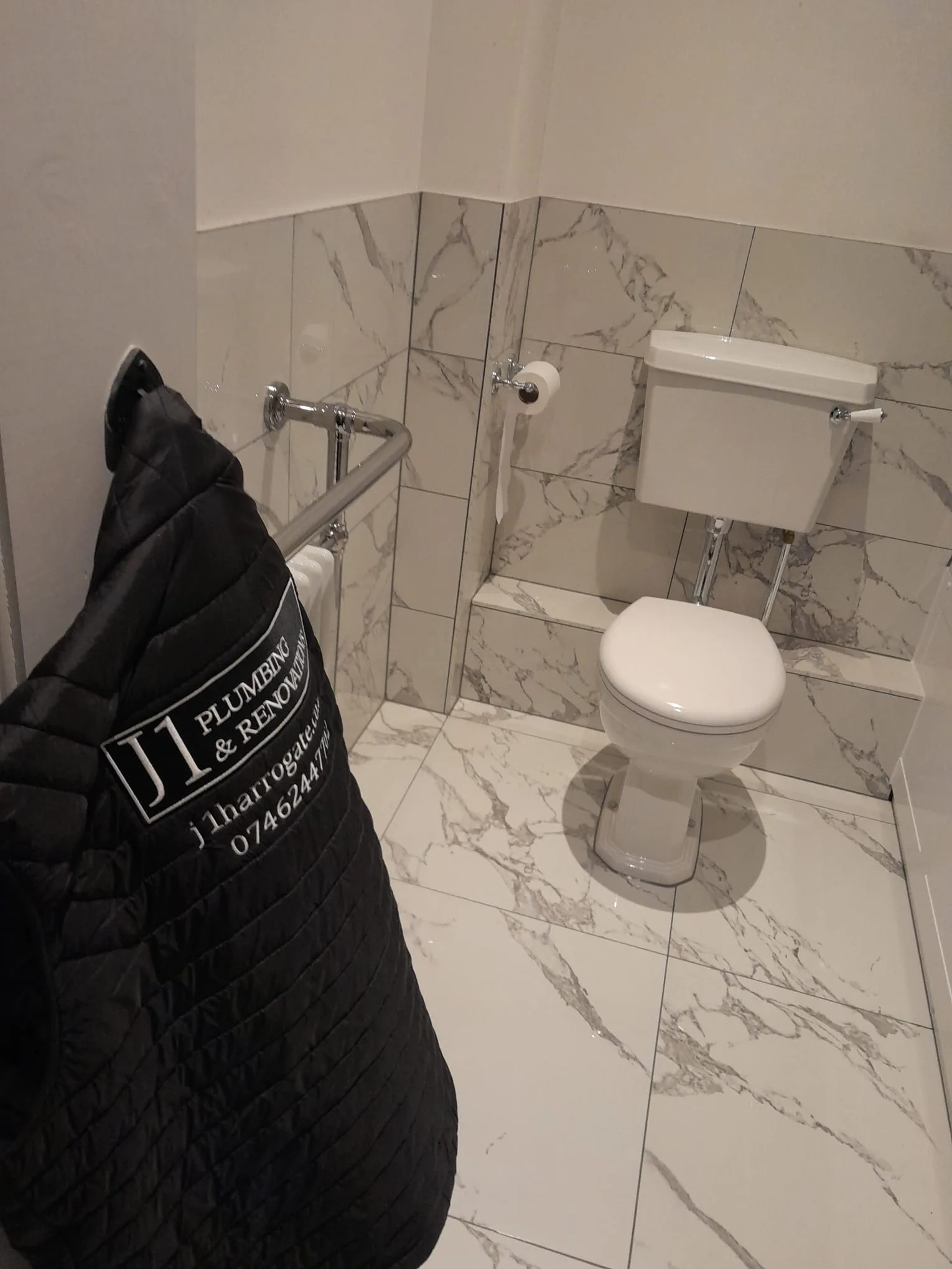 Finished marble-tiled bathroom with high-level cistern, completed by J1 Plumbing & Renovations